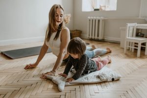 vrouw doet yoga met kind